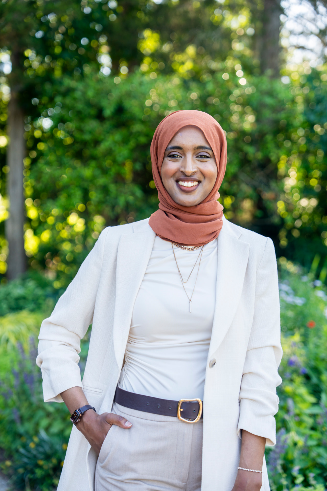 Professional headshot of Salimah Hussien in a cream blazer