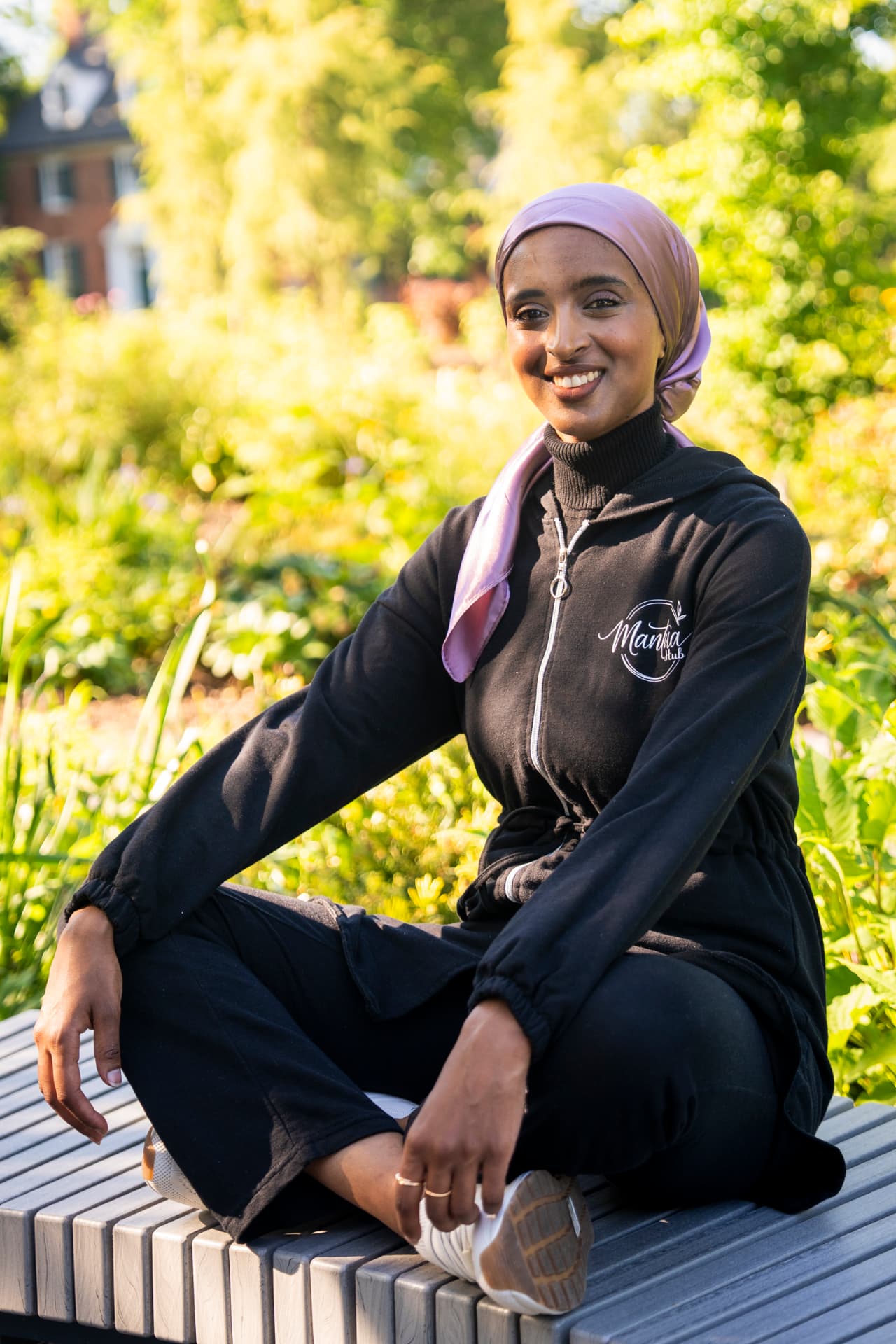 Salimah Hussien seated on a bench in MantuaHub activewear